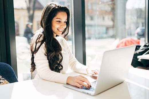 A lady looking happy using her laptop